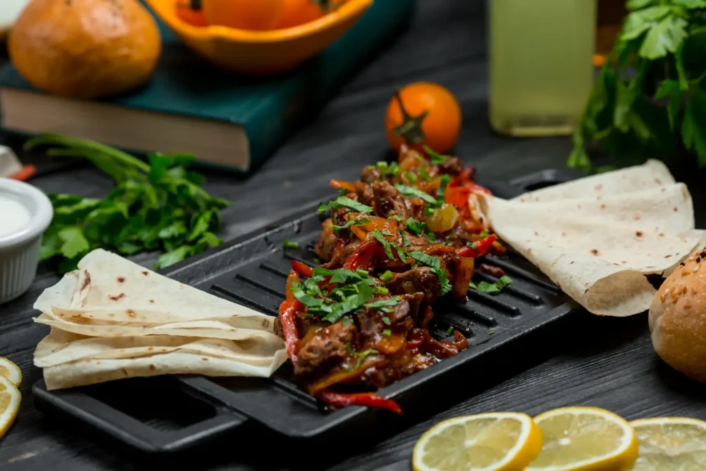 Fajitas de carne mexicanas en Margarita con pimientos y cebolla salteados, servidas con tortillas de maíz y salsas frescas.