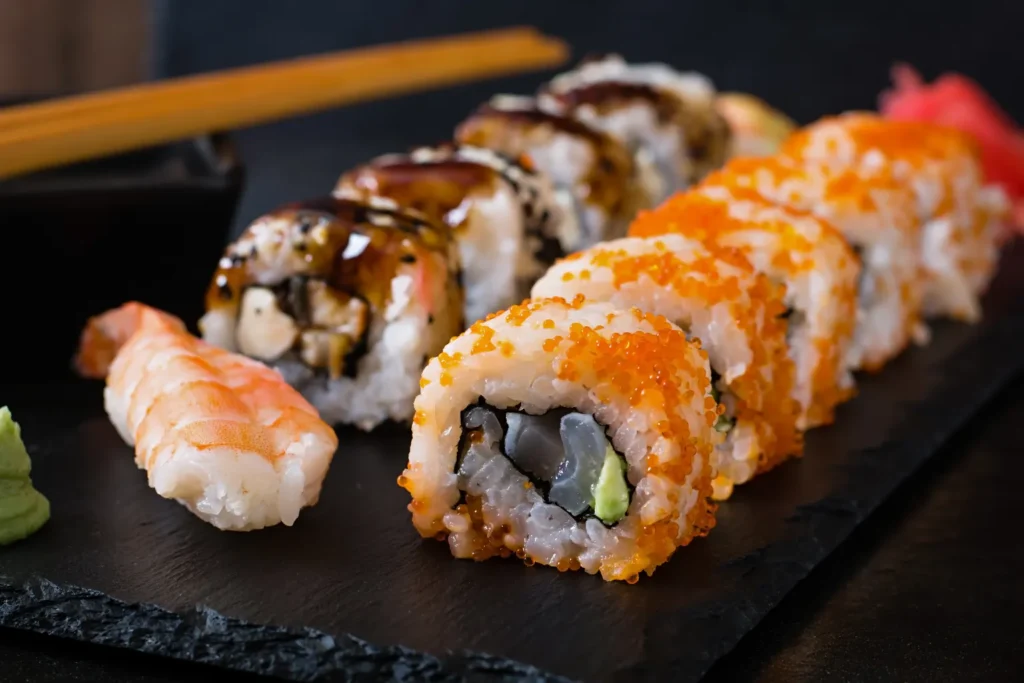 Sushi y rolls frescos para comer en Margarita, servidos sobre bandeja de pizarra