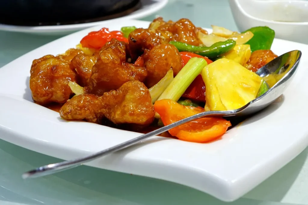 Pollo agridulce chino con pimientos, piña y cebolla en salsa brillante