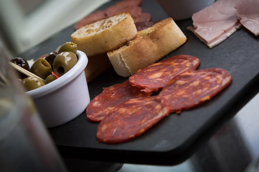 Variedad de tapas españolas con chorizo, aceitunas y pan artesanal
