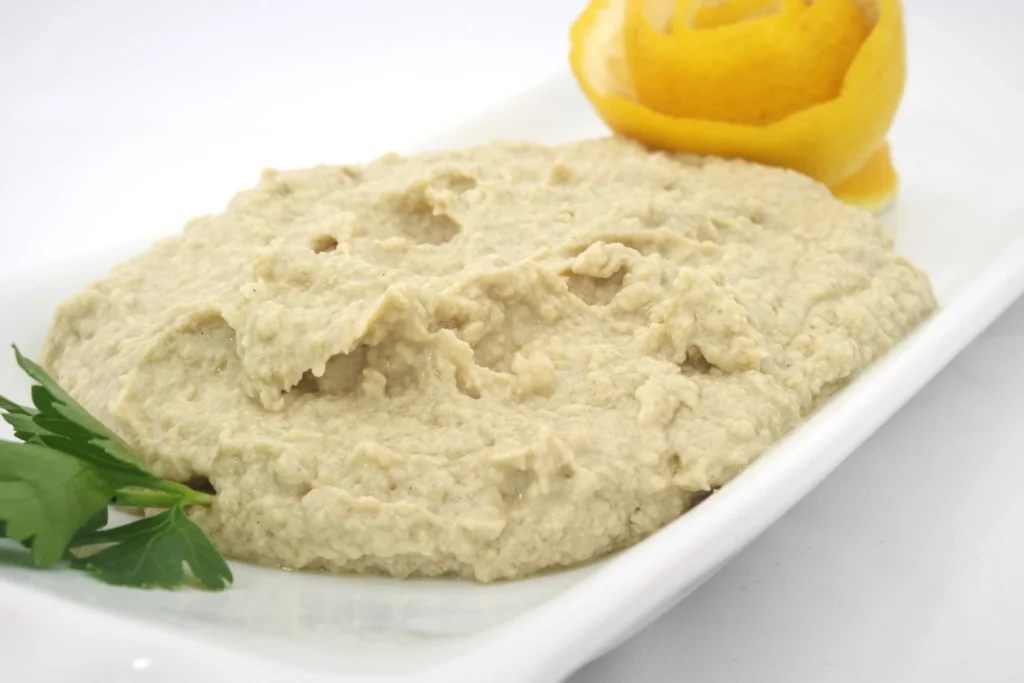 Hummus cremoso de garbanzos con toque de limón, preparado como fuente natural de proteína vegetal.