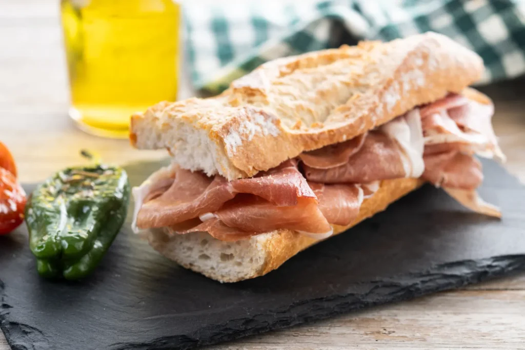 Pan artesanal con jamón serrano y aceite de oliva, una opción sencilla y sabrosa en bodegones de Margarita