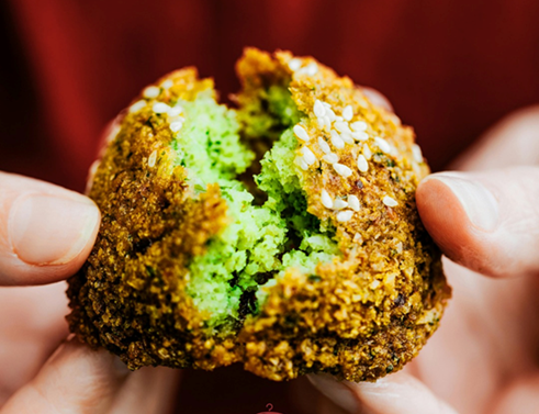 Falafel abierto mostrando su interior verde en La Crema del Shawarma